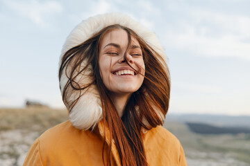 Smiling woman in orange coat with fur hood, fashionable winter outfit for travel and beauty concept