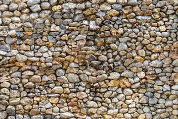 Small stone wall texture for background. Part of a stone wall or pebbles wall, for background or texture