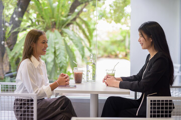 Two women are having a pleasant coffee meeting at a modern cafe with casual and professional vibes