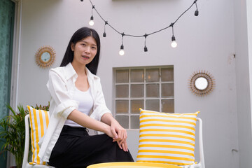 Portrait of Asian woman sitting outdoors and relaxing