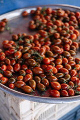 Many small red and brown cherry tomatoes on a counter at a Turkish bazaar