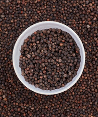 top view background of black peppers (Piper nigrum). Native to Malabar coast of India, it is widely used in culinary as spice and seasoning around the world.