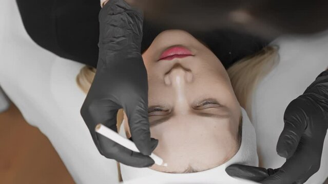 A professional cosmetic procedure for eyebrow microblading is shown in closeup with meticulous precision and attention to detail, highlighting the skill of the expert cosmetologist