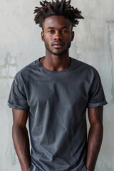 Naklejka premium Man With Dreadlocks Wearing a Gray T-Shirt Posing in Front of a White Wall
