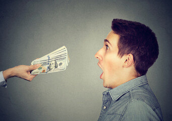 Shocked surprised man looking at offered cash dollar bills