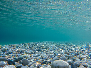 UNDERWATER.Turquoise crystal clear water, pebbles of Tyros beach, Peloponnese, Myrtoan Sea, GREECE. 