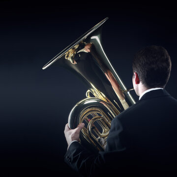 Tuba player. Brass music instrument. Orchestra bass wind euphonium back view