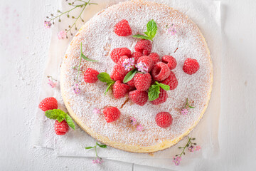 Homemade and sweet cheesecake with powdered sugar and berry fruit.