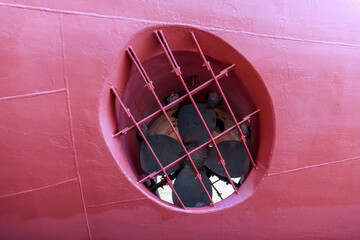 Cargo vessel in dry dock on ship repairing yard. Bow thruster.