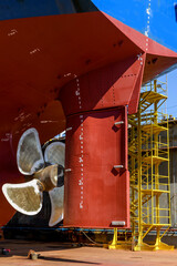 Cargo vessel in dry dock on ship repairing yard. Variable pitch propeller and rudder.