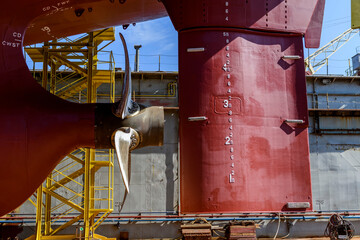 Cargo vessel in dry dock on ship repairing yard. Variable pitch propeller and rudder.