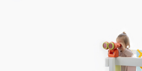 A little girl is looking through a pair of binoculars. Banner size. White background.