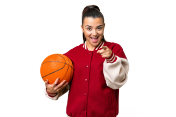Young Woman playing basketball over isolated chroma key background surprised and pointing front