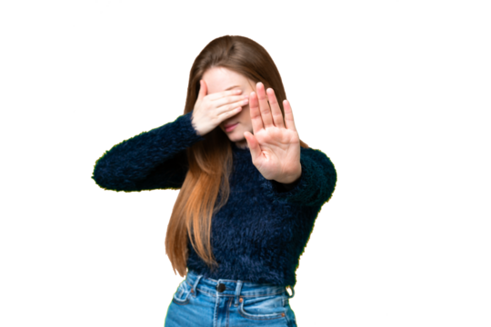 Young pretty woman over isolated chroma key background making stop gesture and covering face