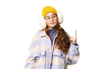 Teenager girl wearing winter muffs over isolated chroma key background showing and lifting a finger in sign of the best