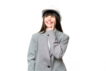 Little girl playing as a architect with helmet and holding blueprints over isolated background thinking an idea while looking up