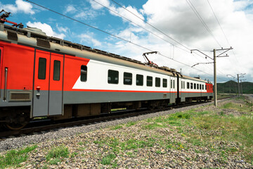 Fototapeta premium red train on railway track in nature, travel concept