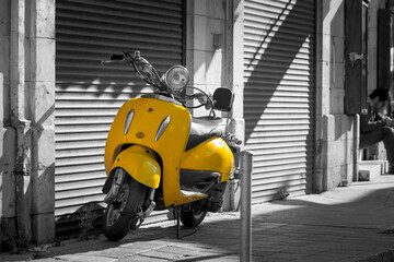 Vintage yellow scooter in the old street