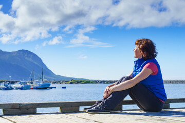 Fototapeta premium Tourist woman in fishing port, Lofoten Norway