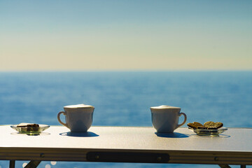 Coffee cups on sea shore. Travel outdoor picnic.