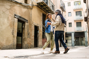 Happy senior couple of tourist having fun dancing at city street during vacation. Happiness and holiday lifestyle concept.