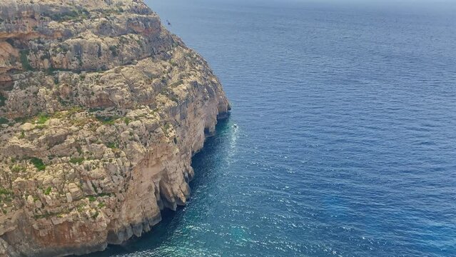 Il-Munqar, Maltese island cliff with natural sea caves on the bottom. View from the Blue vall and Blue Grotto Viewpoint. High quality 4k footage