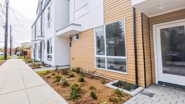 Walking along a city sidewalk in front of a row of empty modern townhomes in an American neighborhood; 4k footage