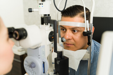 Closeup of a male patient undergoing a vision test performed by an ophthalmologist at a medical...