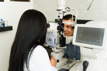 Qualified ophthalmologist conducts an eye examination on a man using advanced diagnostic tools in a clinical environment