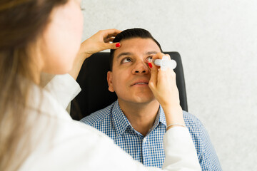 Closeup of an ophthalmologist removing a tear duct obstruction from a patient using a syringe in a...