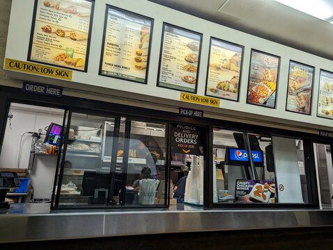 Busy Taco Bell fast food counter with menus and Order Here signage