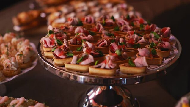 Exquisite appetizers presented on a stylish silver platter in slow motion, perfect for a luxury event or celebration