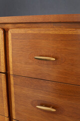 Classic walnut and pecan low dresser. Vintage Mid-century Modern furniture. Close-up detail...