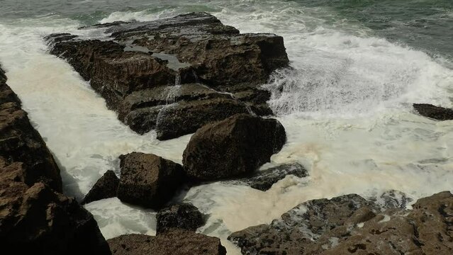 Sea waves with water pollution as a result of human activities. Atlantic coast around Lisboa, rough sea. Ocean aci Long Shot.