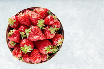 Strawberries in Bowl on Gray Concrete Background, Top View, Copy Space