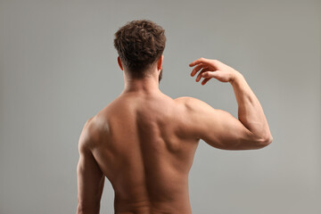 Fototapeta premium Man with muscular body on light grey background, back view