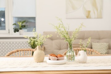 Fresh pastries and beautiful flowers on table in stylish dining room © New Africa