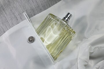 Luxury men's perfume in inner pocket of grey jacket, top view