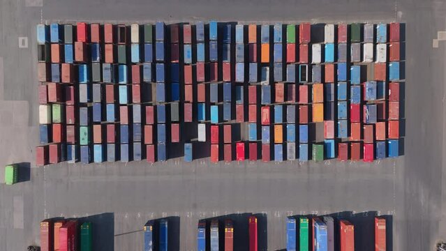 Top down aerial view of shipping containers stacked up at port. Maritime industry and logistics