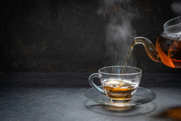 Glass cup of jasmine tea on wood table. Space for text