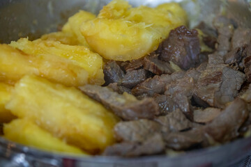 Traditional sun-dried meat with cooked cassava and bottled butter