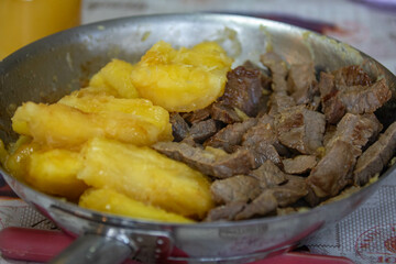 Traditional sun-dried meat with cooked cassava and bottled butter