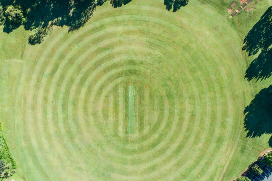Aerial view of a grassy oval with a cricket pitch.