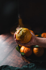 orange juice, holding a very fresh orange in the kitchen, dark food