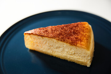 青い皿の上に置かれたチーズケーキ