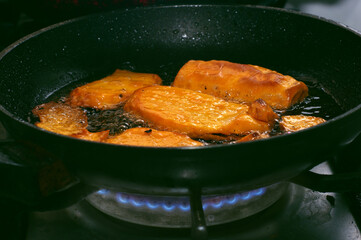 Closeup of frying pan with boiling oil frying sweet potatoes