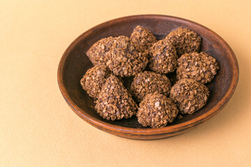 Handmade Chocolate Truffles in a Rustic Ceramic Bowl on Beige Background