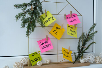 Action board new year's resolutions on colorful sticky notes. Making promises for new year, setting...