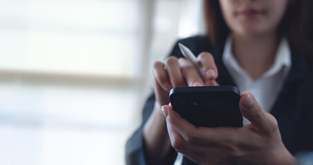 Businesswoman using mobile smart phone and digital tablet computer at office. Asian business woman hand holding smartphone, connecting the internet, online working, corporate business