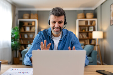 Business man with headsets working on laptop at home office. Customer service assistant working in...